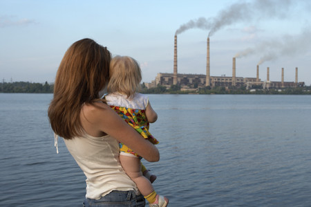 woman with baby observing smokestacks
